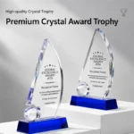 Two sail-shaped K9 crystal awards with globe accents and blue crystal bases