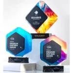 Three colorful crystal and marble award designs on display