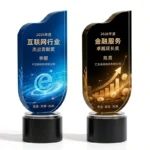 Blue e-network and gold finance crystal trophies with black round bases